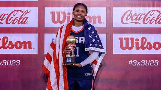 Sania Feagin with the MVP trophy and a U.S flag draped over her shoulders at the FIBA 3x3 U23 World Cup.