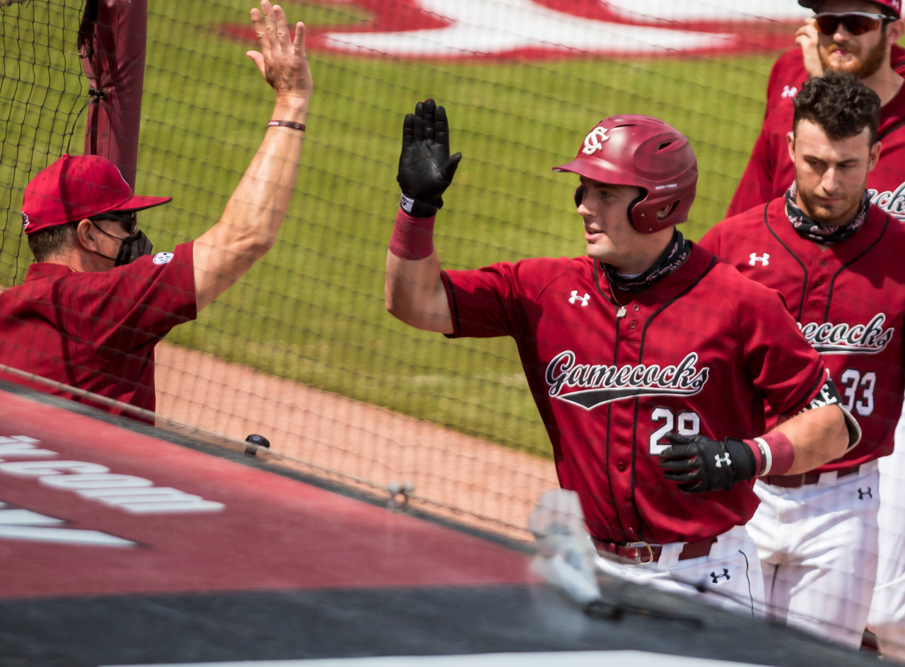 South Carolina Gamecocks catcher Wes Clarke (28) high fives head coach Mark Kingston after hitting a solo home run in the second inning against the Florida Gators.