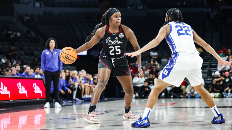 Raven Johnson dribbles on the perimeter with a Duke defender in front of her.