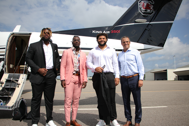 Zacch Pickens, Dakereon Joyner, Jovaughn Gwyn, Shane Beamer pose in front of schoo plane