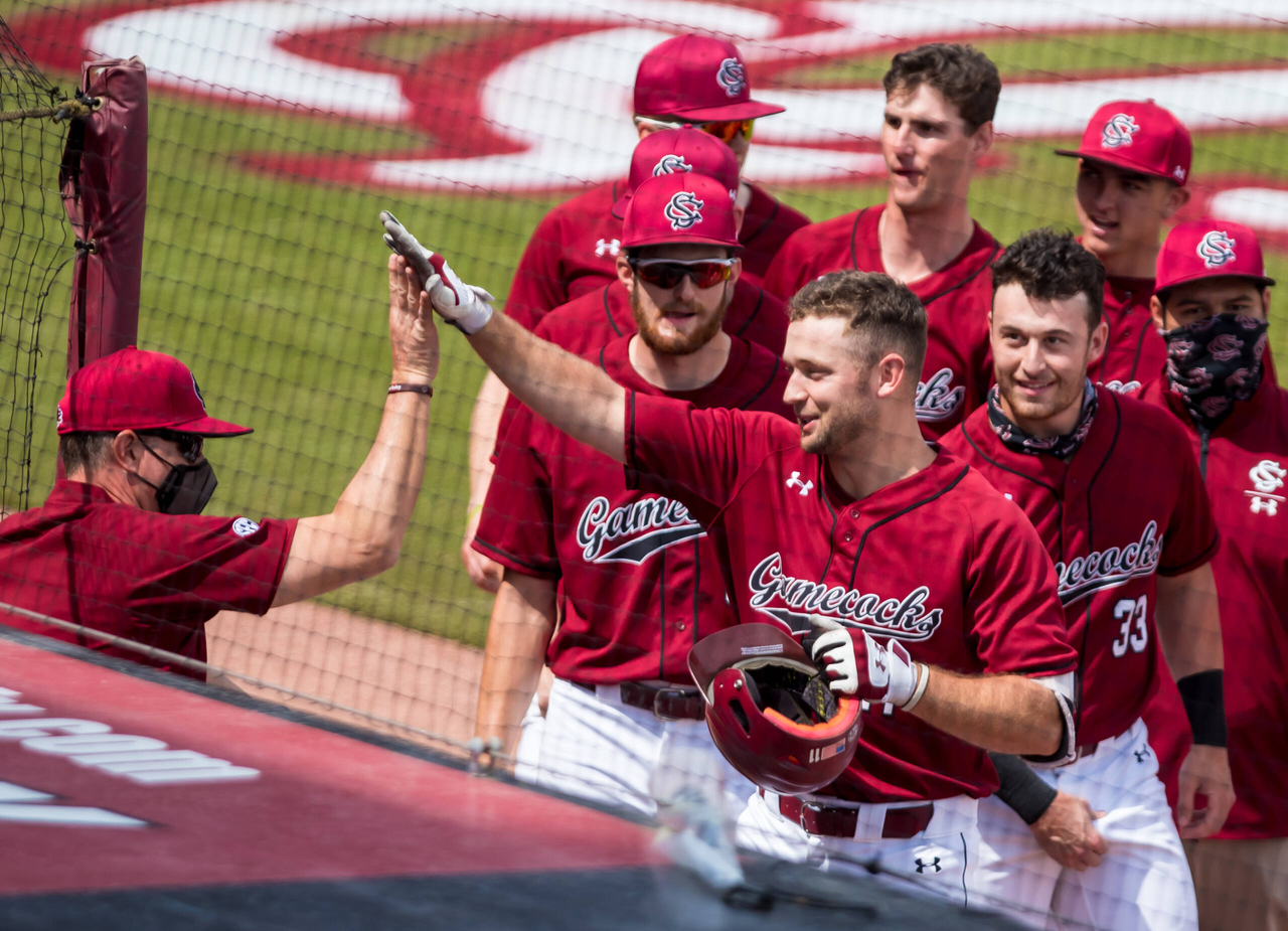 South Carolina Gamecocks outfielder Andrew Eyster (11) high fives head coach Mark Kingston after hitting a home run against the Florida Gators.
