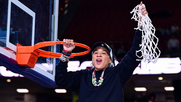 South Carolina head coach Dawn Staley celebrates the 2025 SEC Tournament championship holding the net over her head after cutting the last piece from the rim.