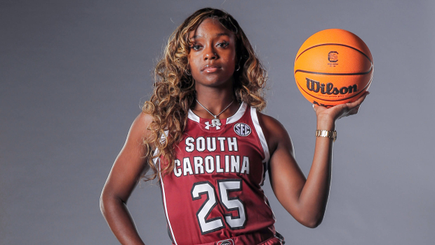 Raven Johnson in studio with right hand on hip and left hand holding ball over her shoulder, 9/11/23
