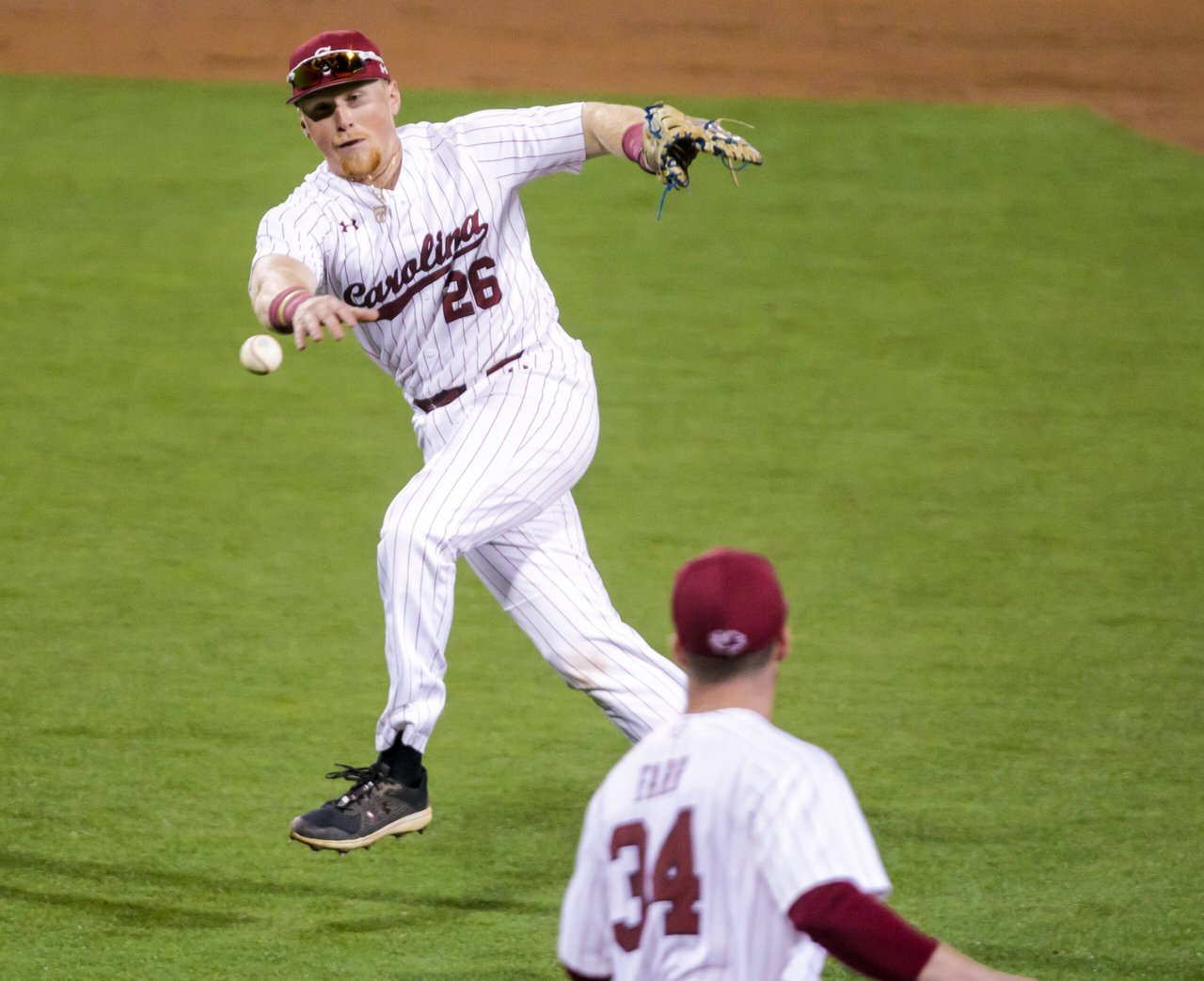 South Carolina Gamecocks infielder David Mendham (26) throws to the pitcher covering, South Carolina Gamecocks pitcher Thomas Farr (34), on a slow grounder. The runner was ruled safe despite video review, the ruling that Farr didnâ??t touch first base.
