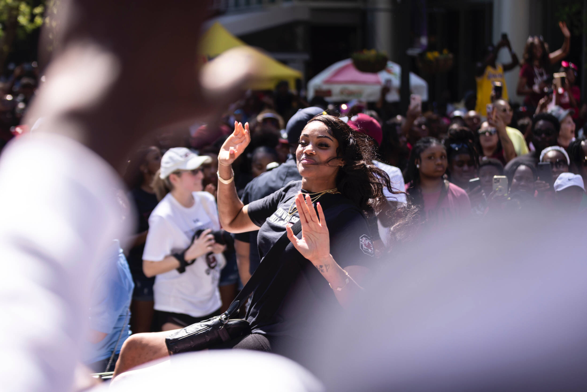 Sakima Walker waves at the crowd riding in the National Championship parade.