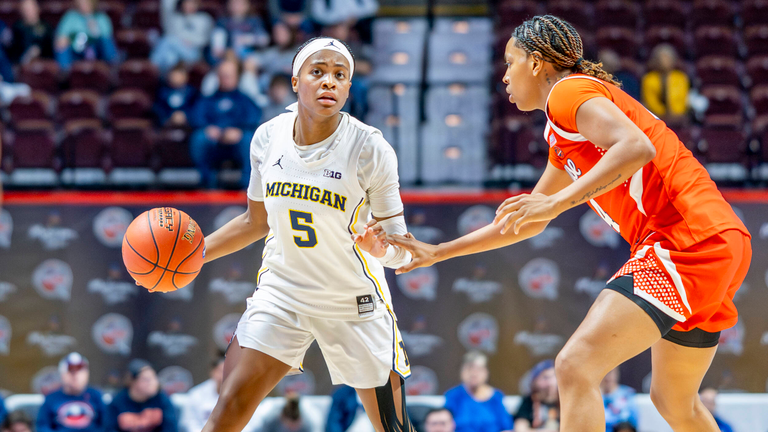 Brooke Daniels, playing for Michigan, looks to drive past a Syracuse defender.