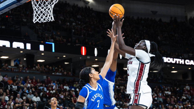 Madina Okot pulls up for a short jumper in the lane over the outstretched arms of two Kentucky defenders.