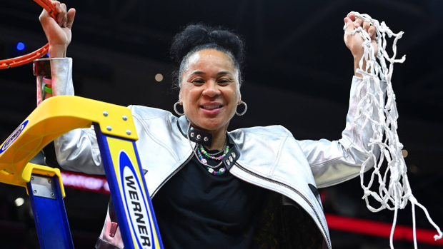 Dawn Staley holds the net from the 2024 National Championship game overhead.