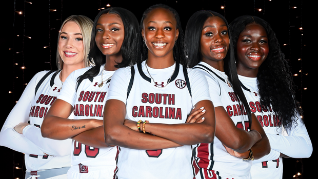 Chloe Kitts, Ta'Niya Latson, Joyce Edwards, Raven Johnson, Agot Makeer posed in white uniforms on a black background.