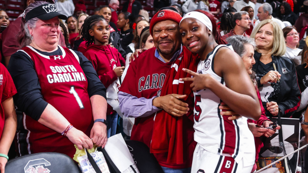 Raven Johnson poses for a photo with a fan with others waiting behind after a game at Colonial Life Arena.
