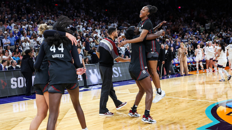 South Carolina players celebrate on the court after defeating UConn,