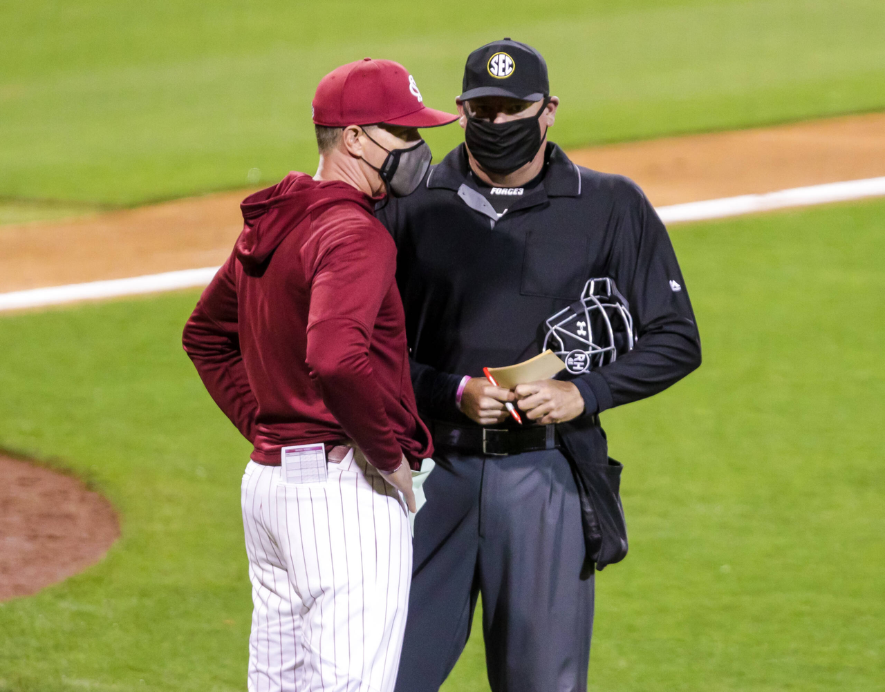 South Carolina Gamecocks head coach Mark Kingston speaks with an umpire during the game against the Arkansas Razorbacks.
