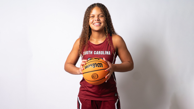Jerzy Robinson in a garnet South Carolina women's basketball uniform on a white background holding a basketball.