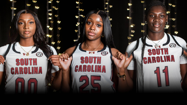 Ta'Niya Latson, Raven Johnson and Madina Okot in white uniforms on dark background