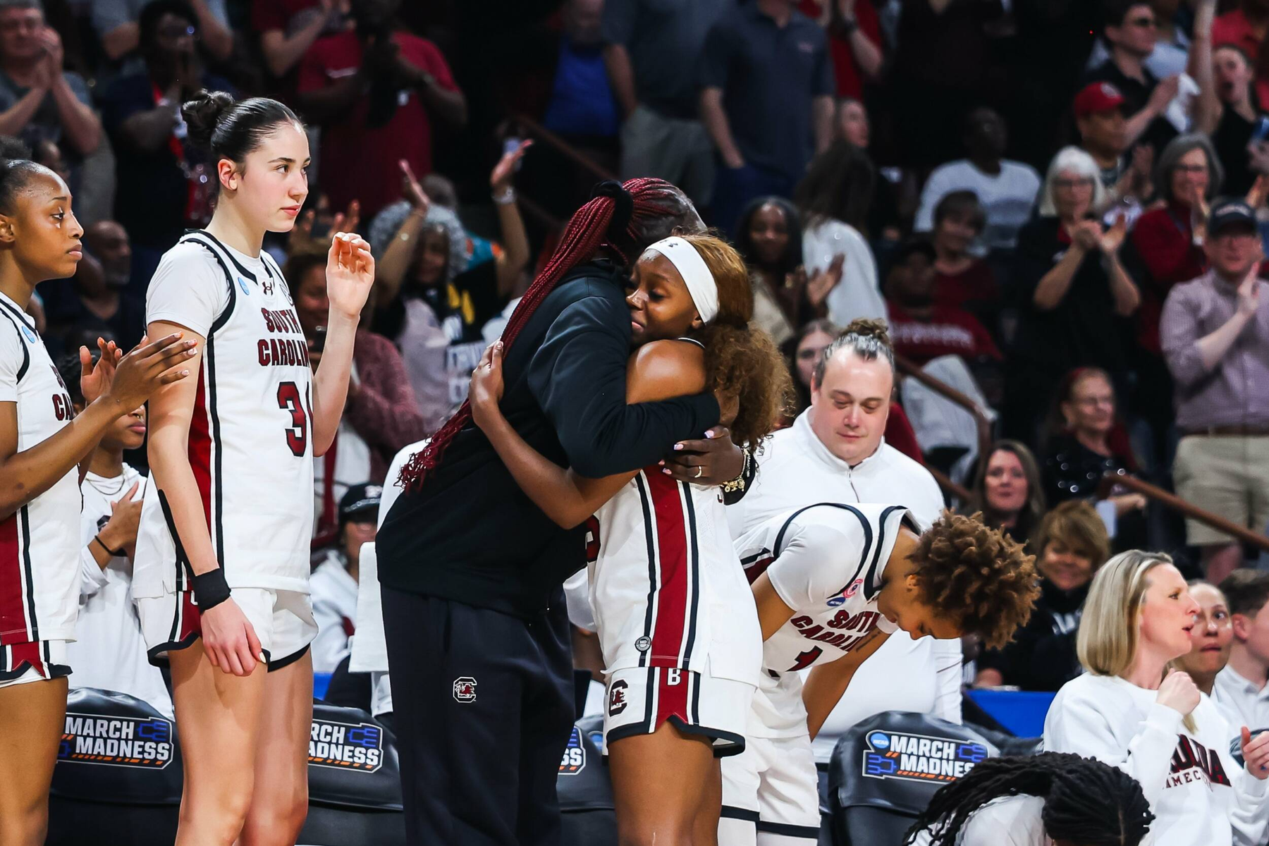 Raven Johnson and coach embrace on sideline